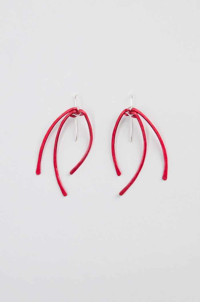 Arc Earrings – Crafted from anodised aluminium, these earrings feature three curved red stems suspended from sterling silver hooks, and are displayed on a plain white background.