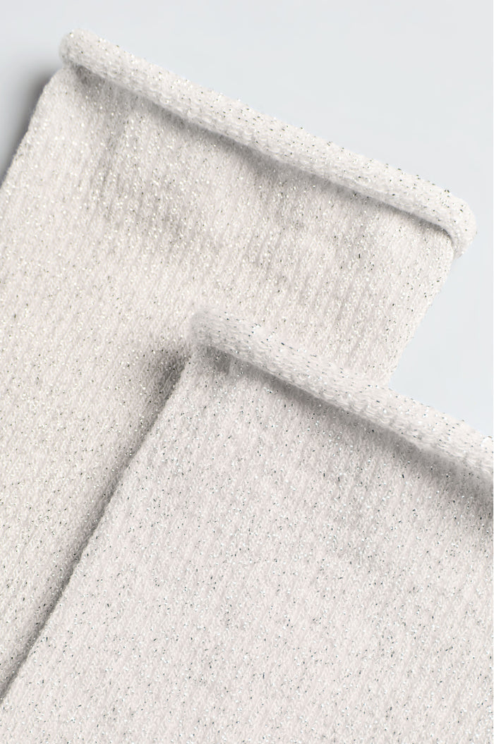Close-up of two light grey, ribbed knit cuffs with a rolled hem, lying flat—showcasing the soft texture and comfort of Bamboo Sparkle Cloud Socks against a plain background.