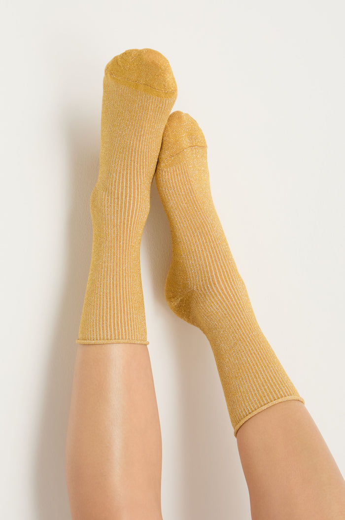 Two legs raised against a white background, wearing Bamboo Sparkle Dijon Socks.