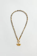 The Dalmatian Stone Ginkgo Leaf Necklace features gold and silver beads, a textured ginkgo leaf pendant, and a toggle clasp, displayed on a flat neutral background.