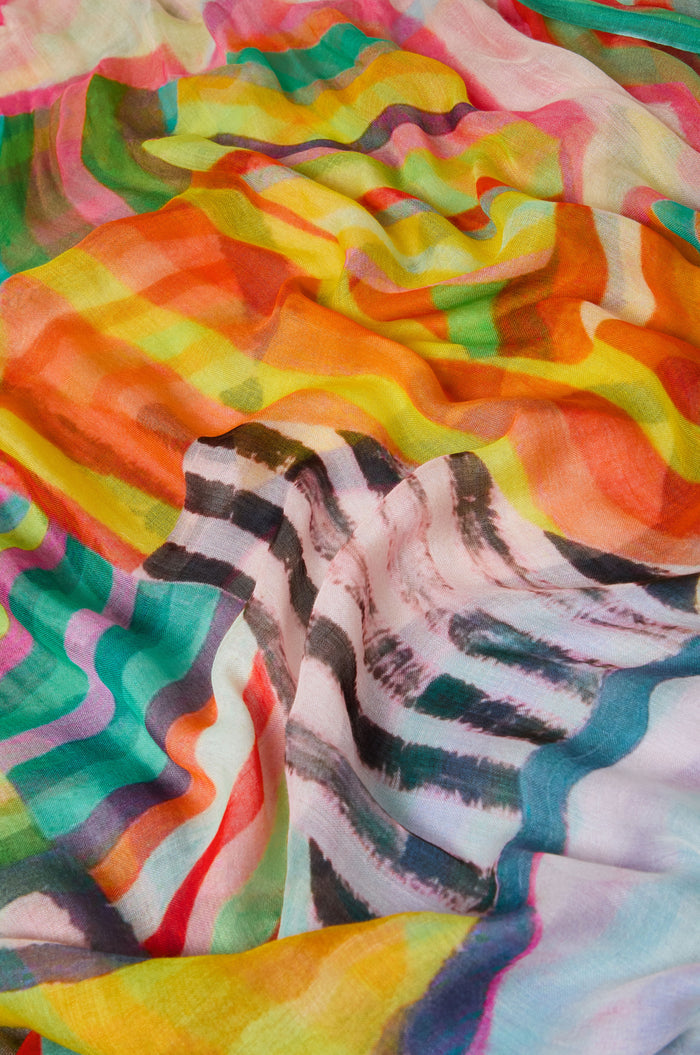 Close-up of the Directional Stripe Modal Blend Scarf, a lightweight accessory with vibrant wavy patterns in yellow, orange, red, green, pink, and black.