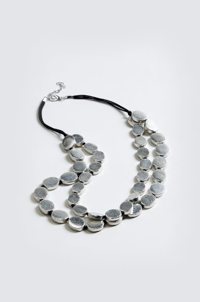 Double Strand Oval Disc Necklace with large, textured silver-toned oval discs on a black cord, shown against a plain light gray background.