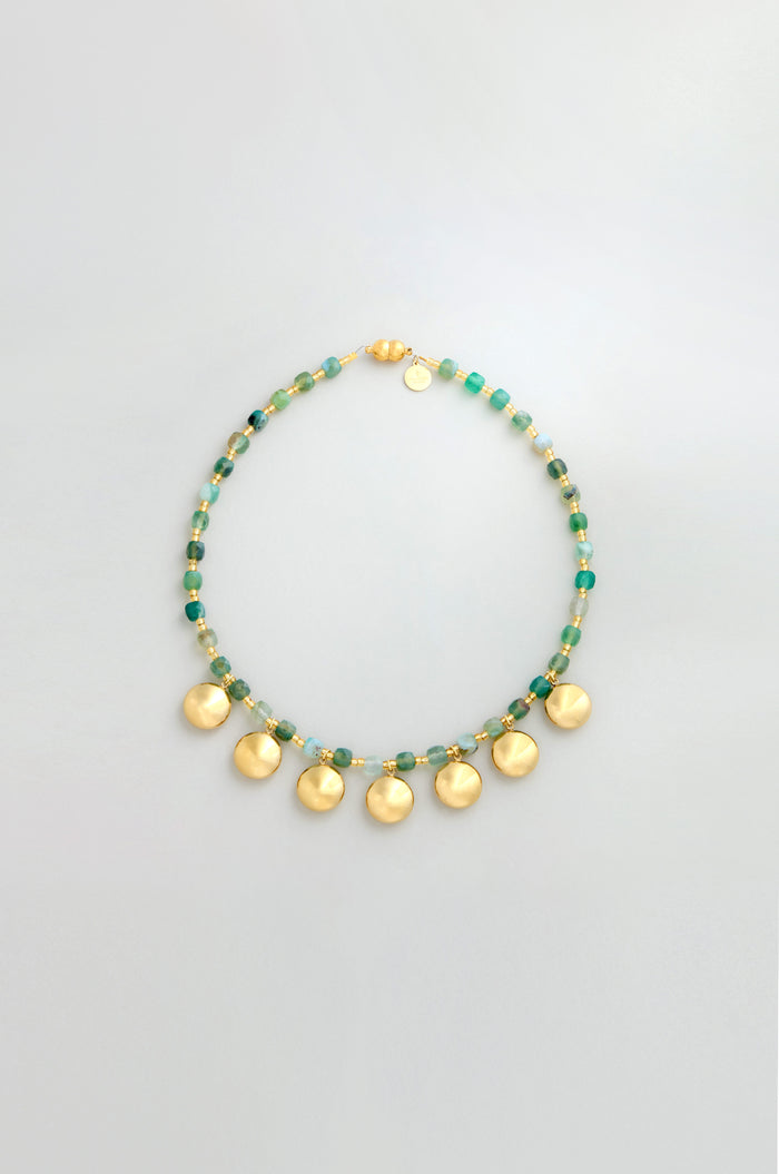 The Faceted Green Agate Charm Necklace features green agate beads, gold and green bead accents, and six round gold pendants evenly spaced for a striking charm necklace look.