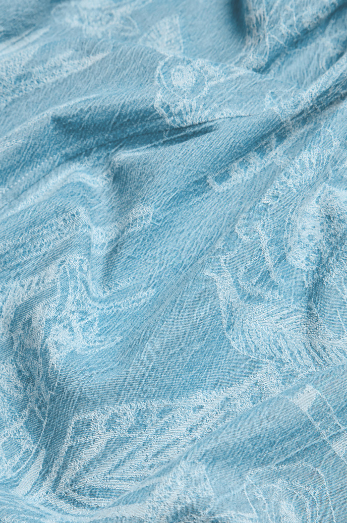The Floral Jacquard Cotton Bubble Trouser features light blue cotton with subtle white animal motifs, soft drape, and textured surface—ideal for pairing with cropped bubble tops or styled as a statement piece.