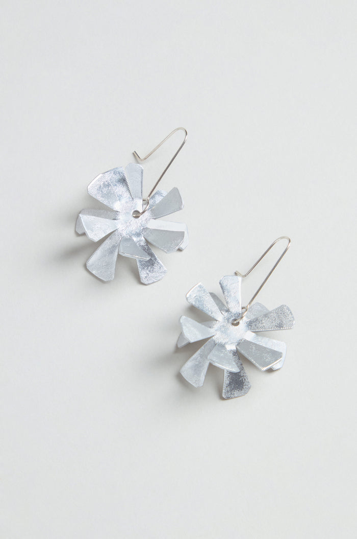 Flower Earrings: Silver metallic floral design crafted from anodised aluminium with sterling silver hooks, shown on a light grey background.