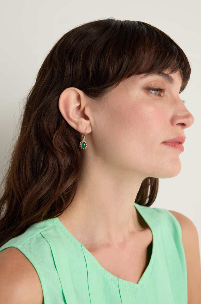 Woman with long brown hair wears a sleeveless mint green top and elegant Gold Vermeil Green Onyx Earrings, shown in profile against a plain light background.