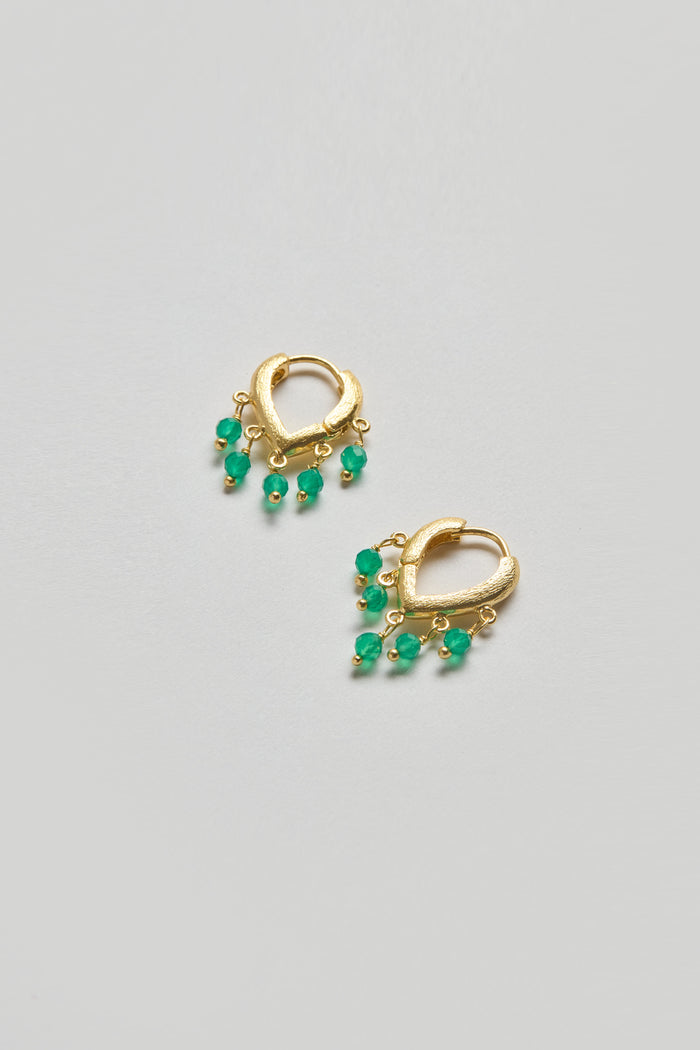 The Gold Vermeil Onyx Teardrop Hoops are pictured on a light gray background, featuring a pair of gold vermeil hoops each adorned with five small green beads.