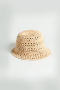 The Handwoven Raffia Bucket Hat, crafted in a beige crochet style from Madagascar straw, is displayed on a plain light background.