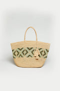 The Handwoven Raffia Mosaic Bag features two handles, a blue, green, and black geometric pattern, and two tassels attached to one handle.