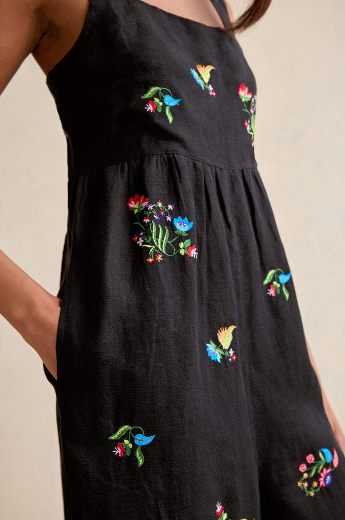 A person wearing the Vintage Floral Embroidered Jumpsuit stands with one hand in a pocket.