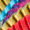Close-up of the Long Pleated Necklace, arranged in vibrant diagonal rows—blue, purple, yellow, and red hues create a striking statement accessory reminiscent of colorful pleated patterns.