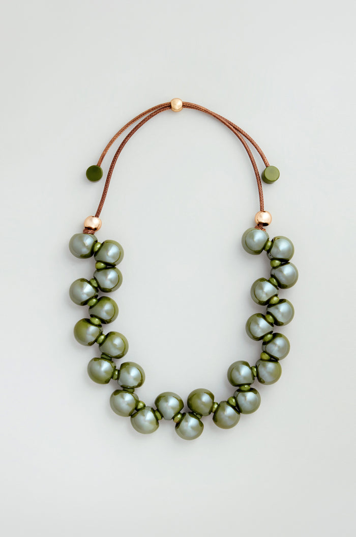 The Macrame Resin Bead Necklace features large, round olive-green resin beads on a brown cord with gold accents and an adjustable closure for a perfect fit.