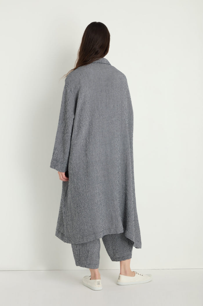 A person stands with their back to the camera against a white background, wearing the Micro Gingham Boxy Coat with matching loose pants and white sneakers.