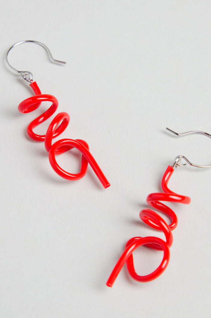 The Mini Sketch Earrings feature bright red, spiral-shaped dangles on silver hooks. Handmade in Paris, they're perfect for lovers of colourful jewellery and are shown displayed against a light background.