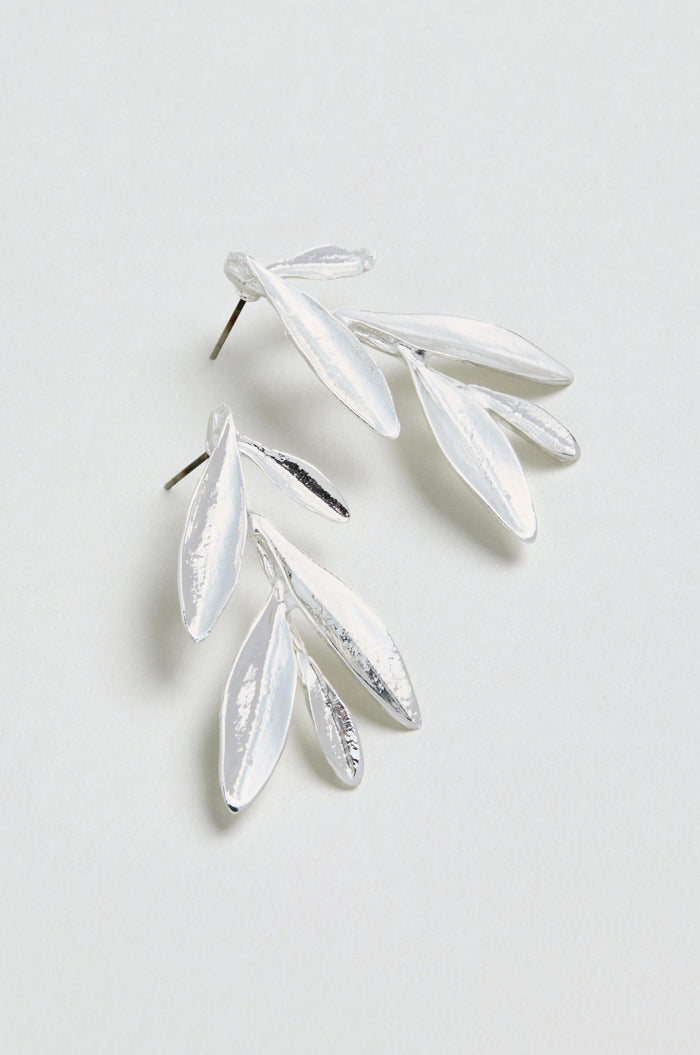 A pair of Olive Branch Earrings, silver plated and shaped like delicate leaves, displayed on a light, neutral background.