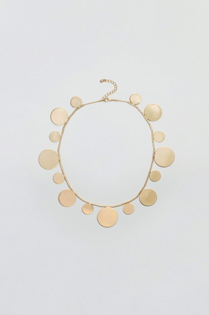 Orbit Disc Necklace featuring multiple flat, round discs of varying sizes evenly spaced along a thin chain, finished with a lobster clasp and adjustable extension at the top.