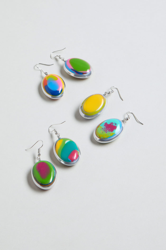 Five pairs of Rainbow Pebble Earrings with silver hooks, each displaying a colorful abstract swirl in green, yellow, pink, blue, and orange tones, are arranged on a white background.