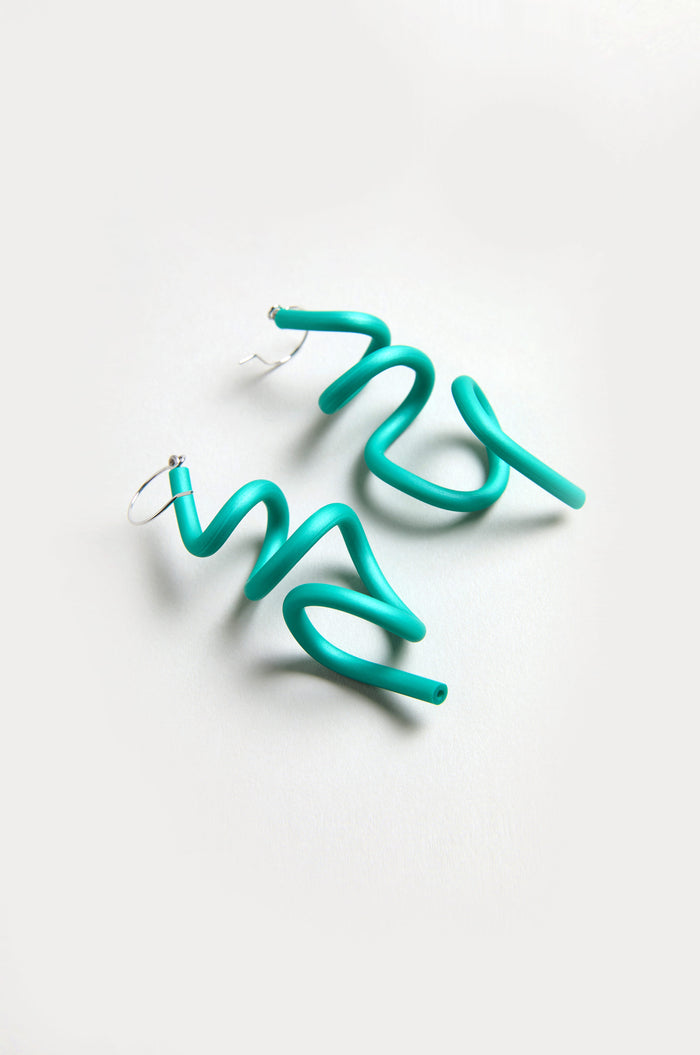 A pair of bright turquoise Sketch Earrings in a spiral shape with hoop fastenings, displayed on a light background.