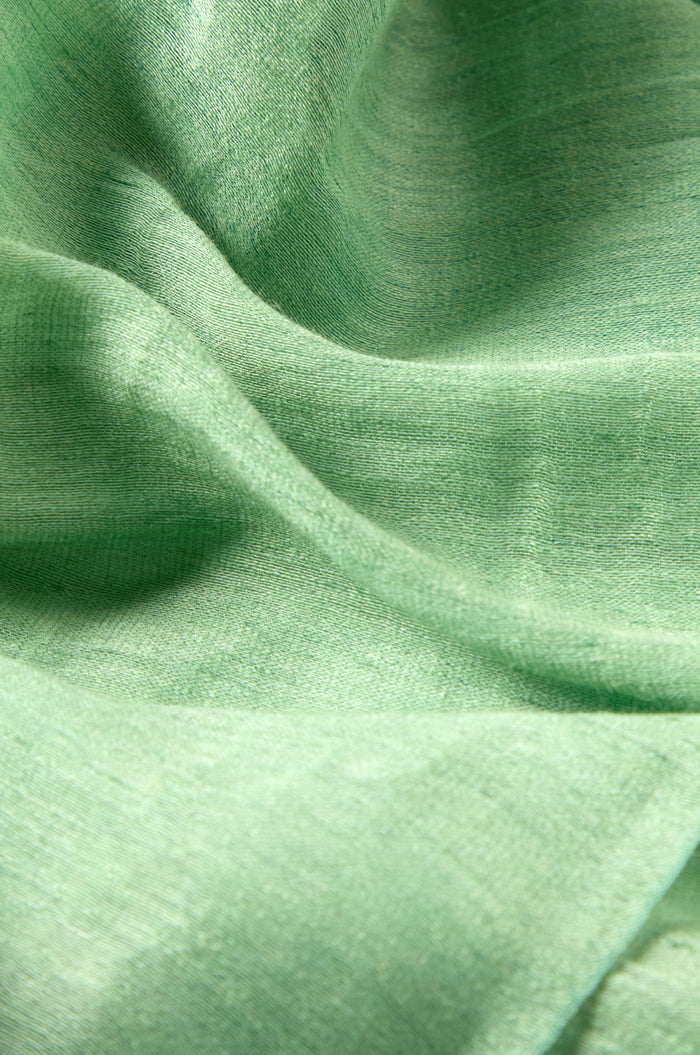 Close-up of an Olive Soft Linen Fringe Scarf, featuring a light green linen-silk blend with a smooth texture and visible folds—ideal for a lightweight accessory.
