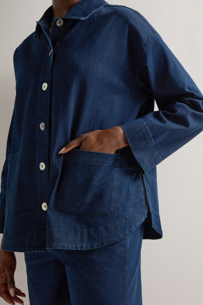 A person stands against a light background, wearing the Stretch Denim Jacket with a boxy silhouette and one hand in the pocket.