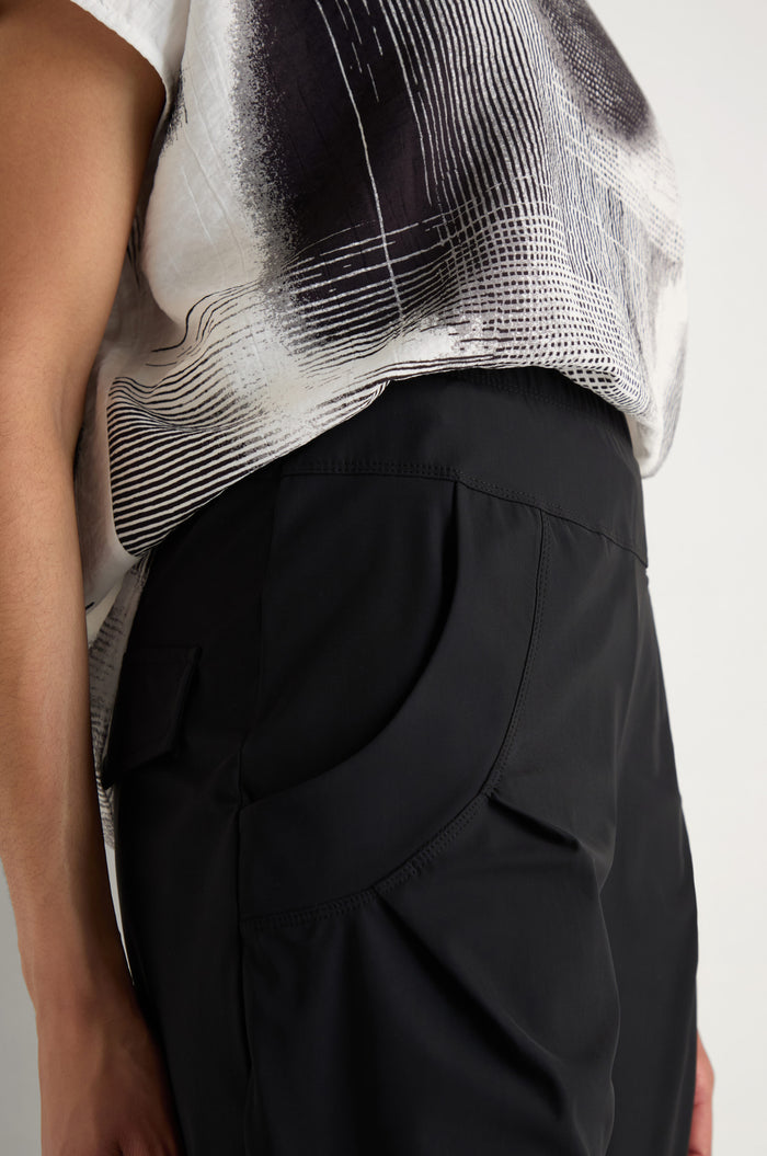 A person wearing Tapered Cuff Trousers with their right hand in the pocket, shown from waist down against a plain background.
