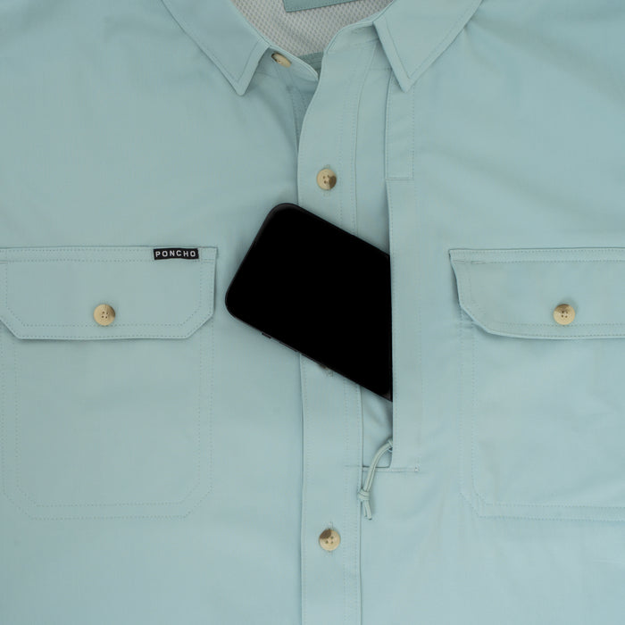 Light blue "The Antilles" outdoor shirt with chest pockets and hidden zippered compartment holding a phone