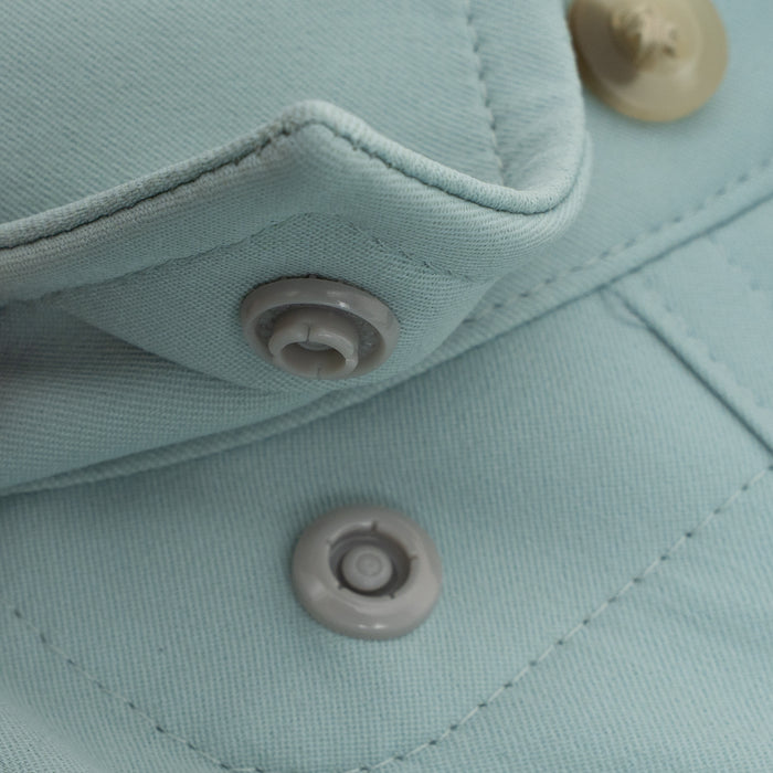 Close-up of light blue fabric with snap buttons on The Antilles outdoor shirt