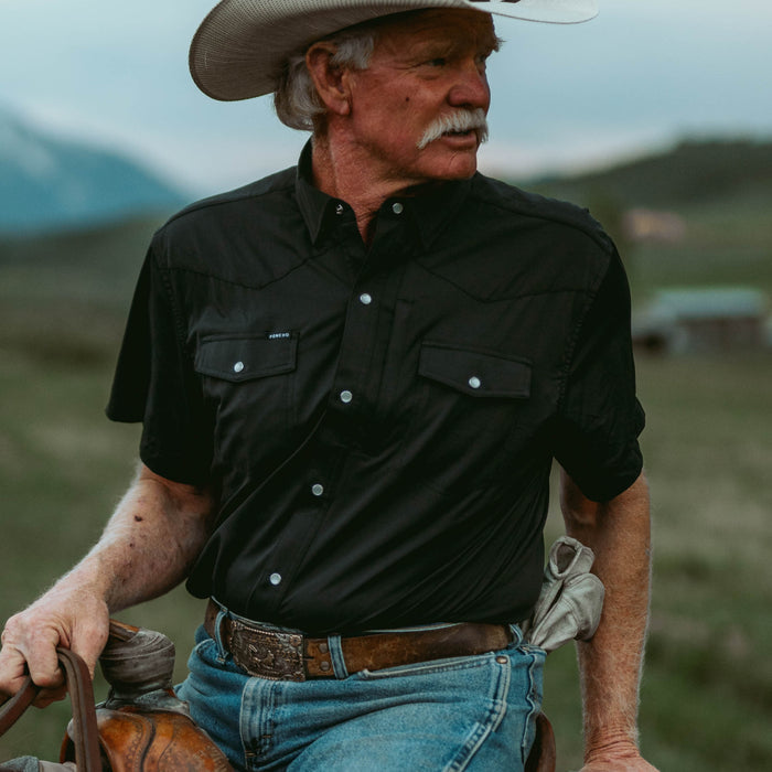 Man wearing The Bandera breathable outdoor shirt with a cowboy hat in a rural landscape