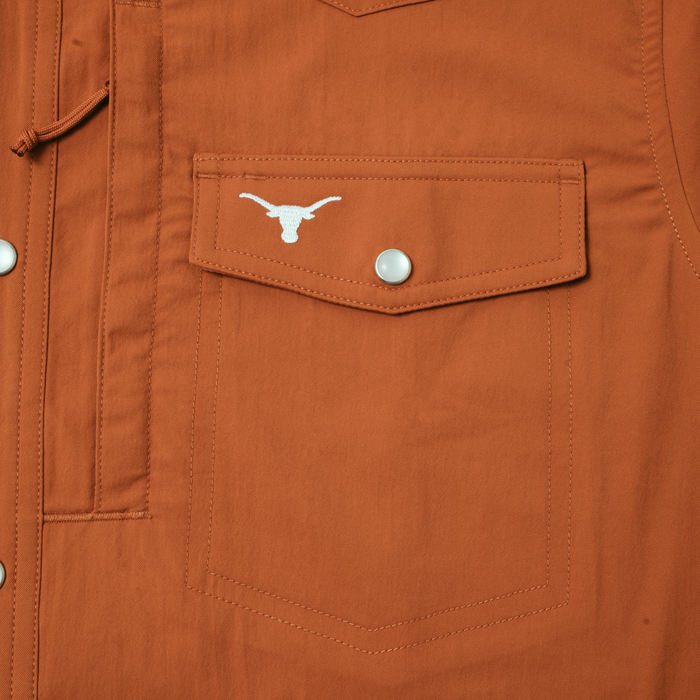 Close-up of burnt orange pocket with snap button and white logo on The Bertha shirt