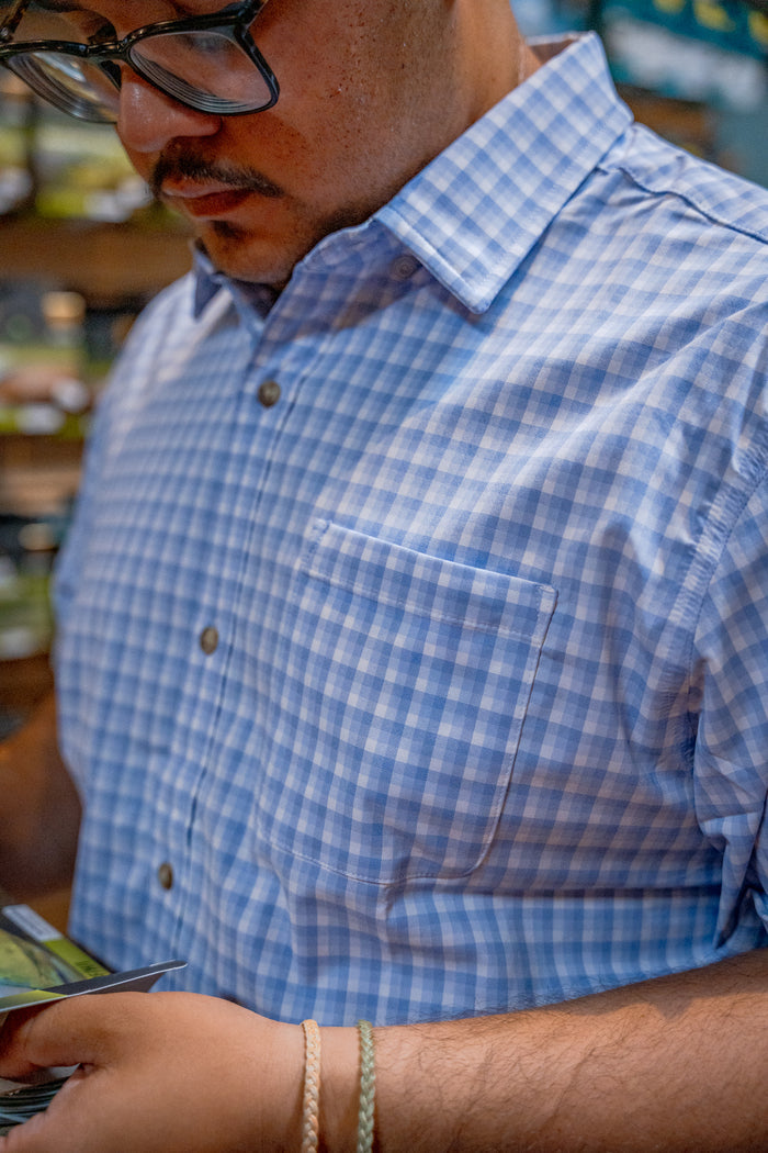 man reading in blue check shirt