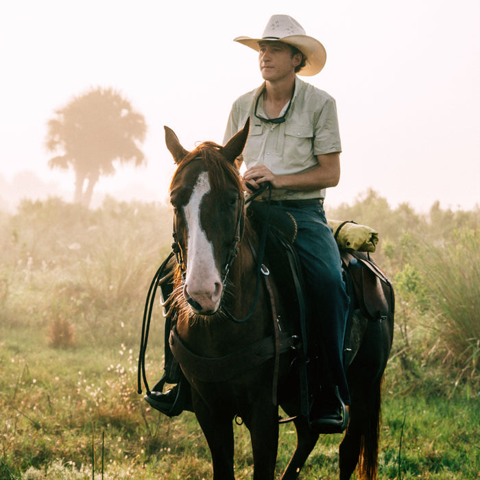 man riding a horse while wearing The Buckskin