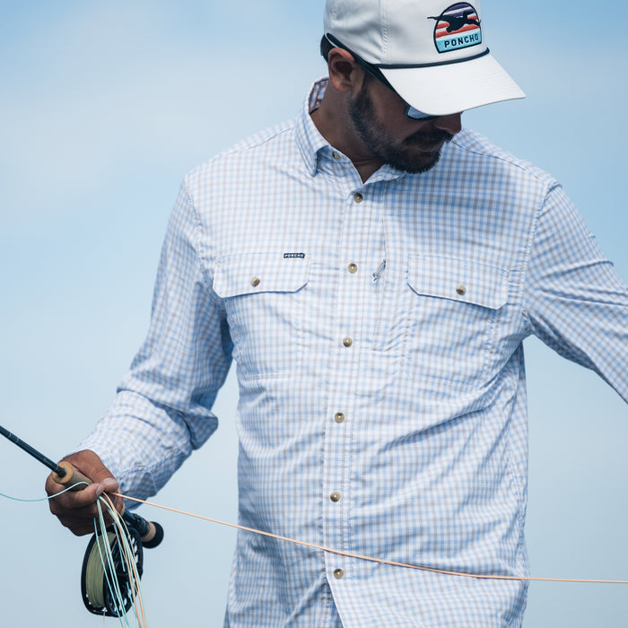 man holding fly rod wearing grey plaid long sleeve shirt