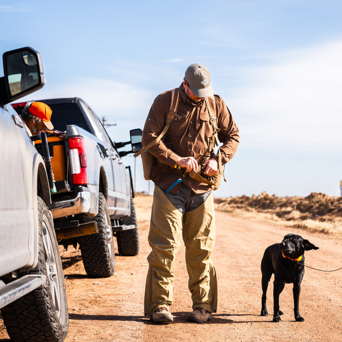 Man wearing The Clark shirt outdoors by trucks with black dog on leash