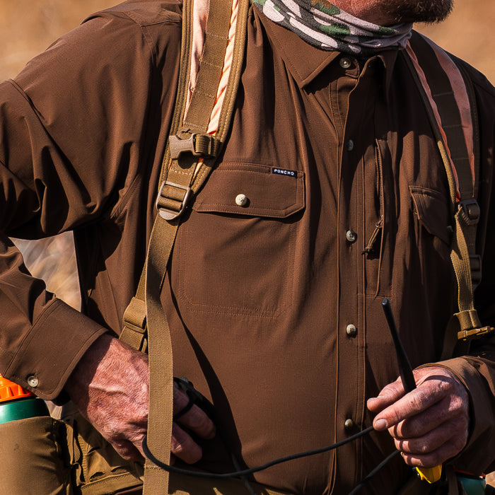 Close-up of a man wearing The Clark brown outdoor shirt with backpack straps
