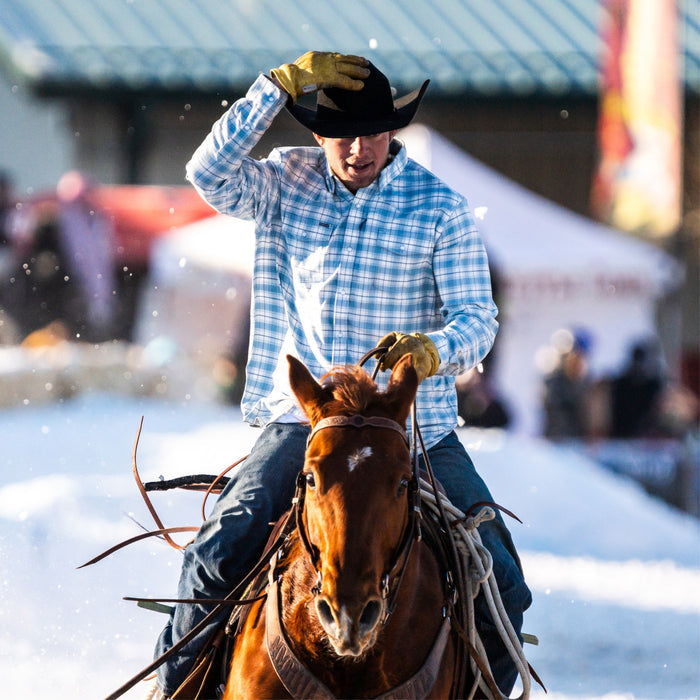 Man in cowboy hat wearing the cody riding horse