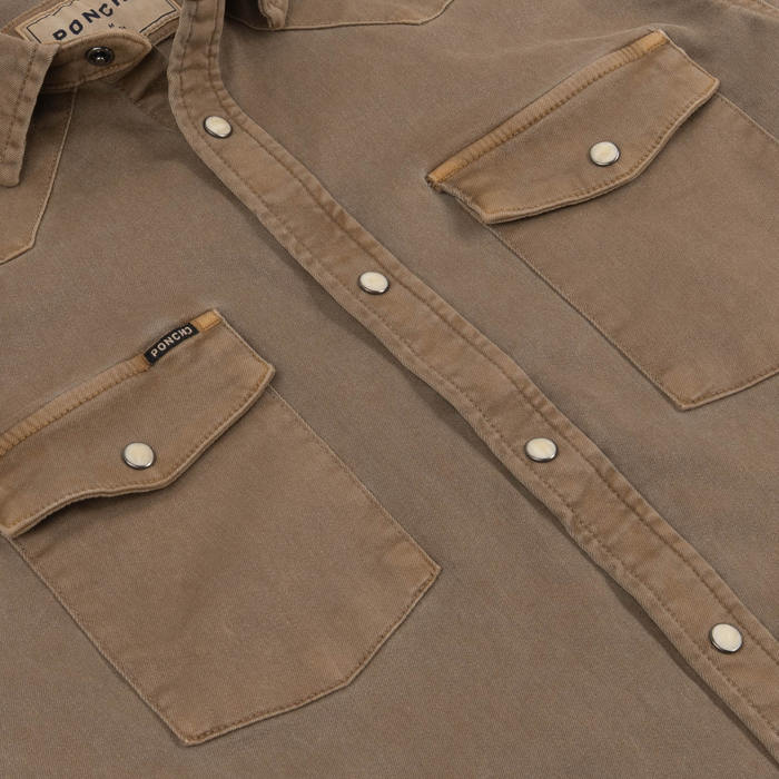 Close-up of The Cotulla shirt showing durable fabric, snap buttons, and two front flap pockets.
