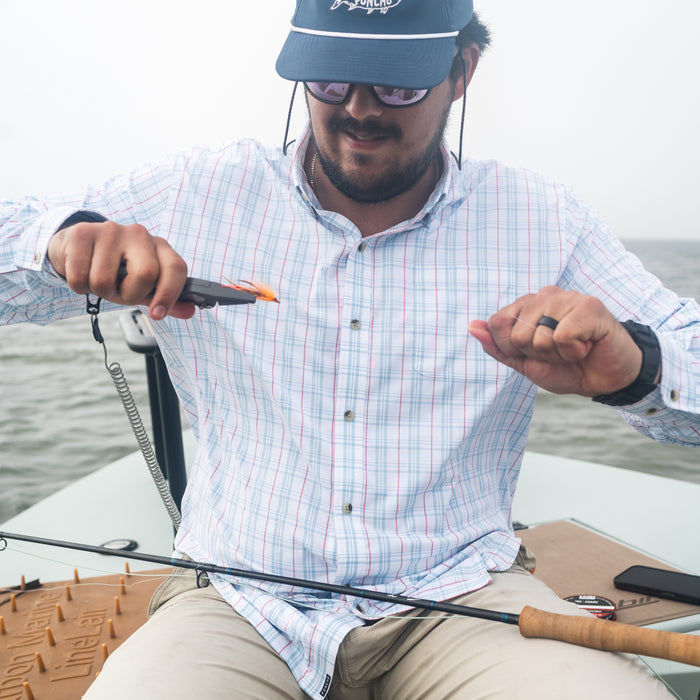 Man tying on a fly in The Croaker shirt