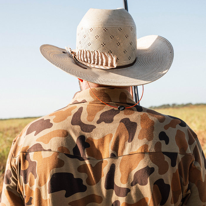 man with cowboy had wearing camo polo shirt