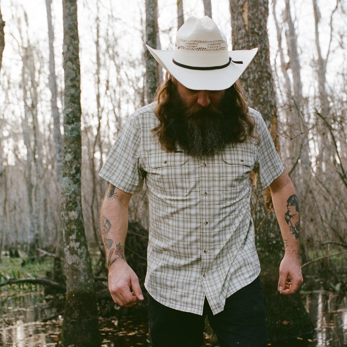 man wearing The Everglades shirt while walking through a swamp