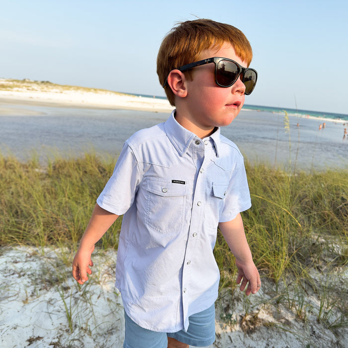 kid on the beach wearing blue pearl snap short sleeve shirt