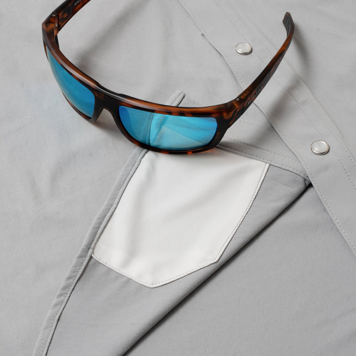 sunglasses with lens cleaner on grey shirt