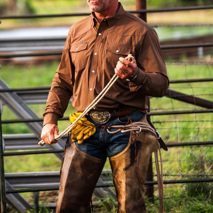 Man wearing The Lewis outdoor shirt holding rope in ranch setting