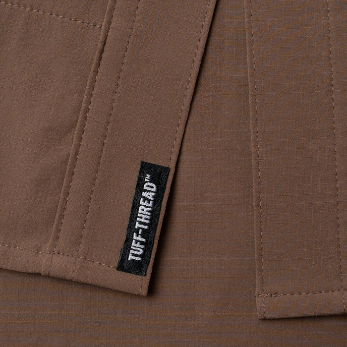 Close-up of durable brown fabric with Tuff-Thread label on The Lewis outdoor shirt