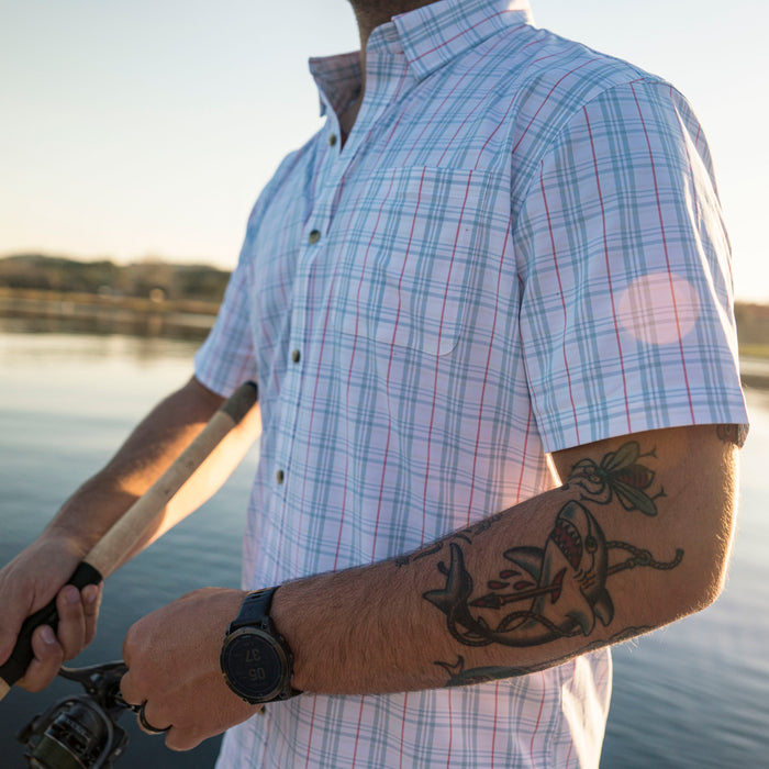 Man wearing The Mullet outdoor shirt while fishing by the lake