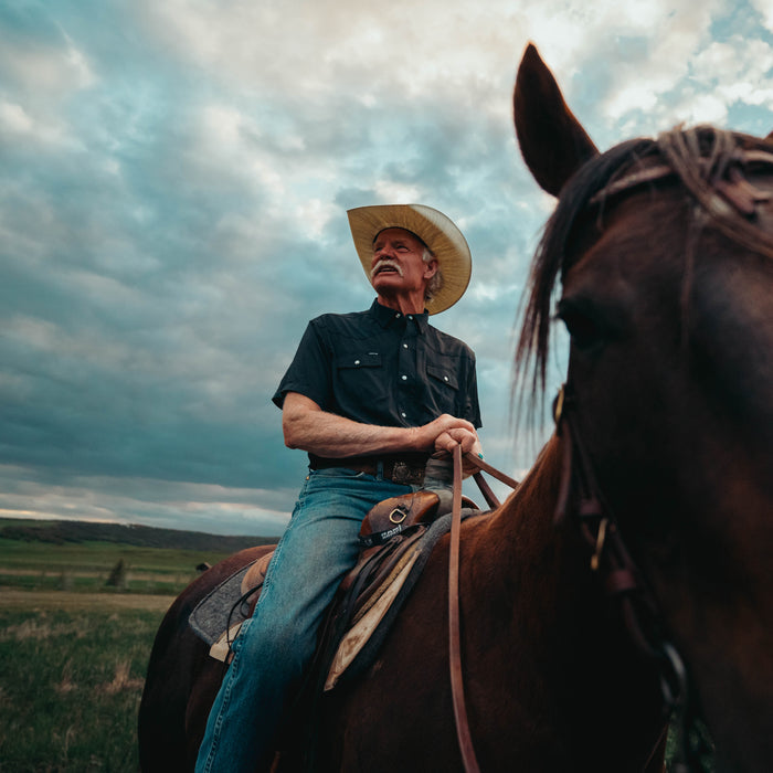man wearing black shirt while riding horse