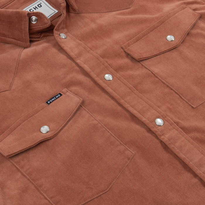 Close-up of The Red Bud shirt in warm brown fabric with snap button pockets and a collar detail.