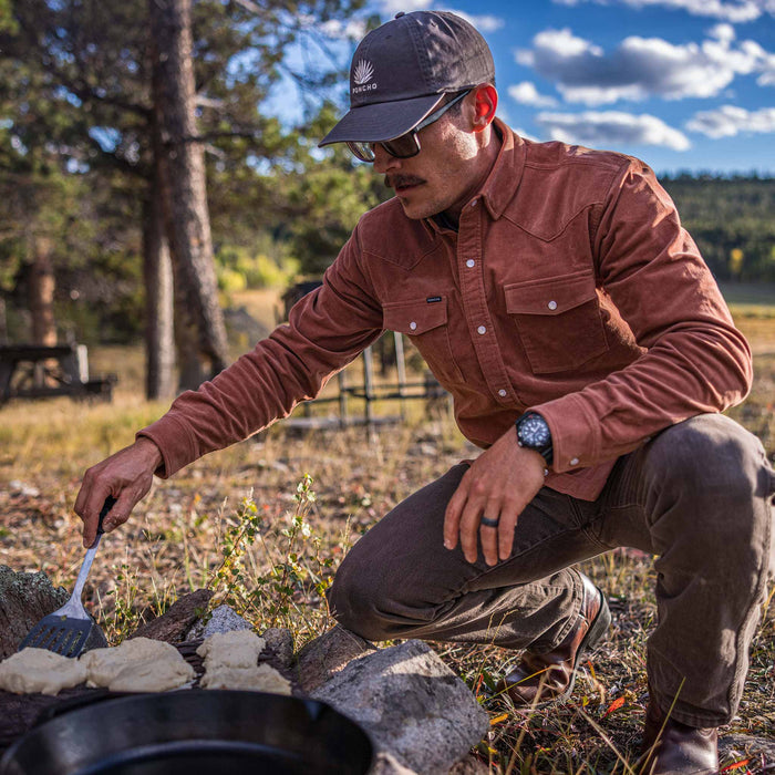 guy wearing shirt tending to fire