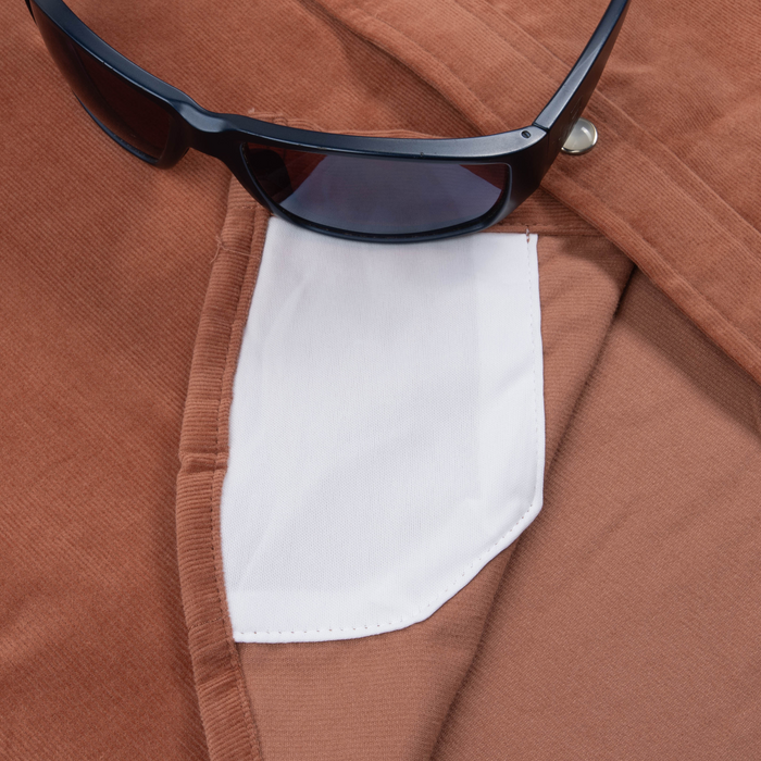 Close-up of The Red Bud shirt fabric and pocket detail with a pair of black sunglasses resting on top.