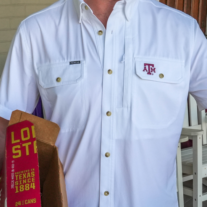 Close-up of a white "The Reveille" shirt with snap buttons and branded chest pockets