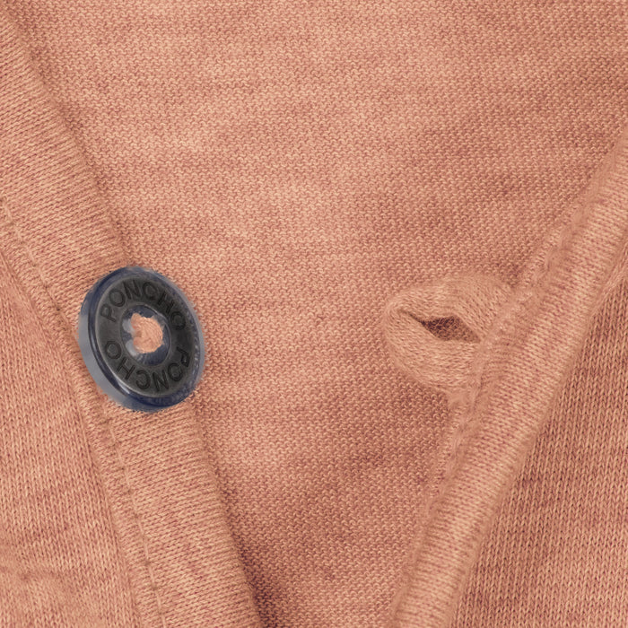 Close-up of a brown knit fabric with a black button labeled Poncho on The Rusty Pliers shirt